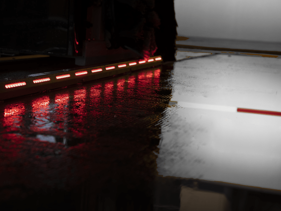 Nice detail of the red LED lights of the starguide wheel guides reflecting in the wet carwash floor