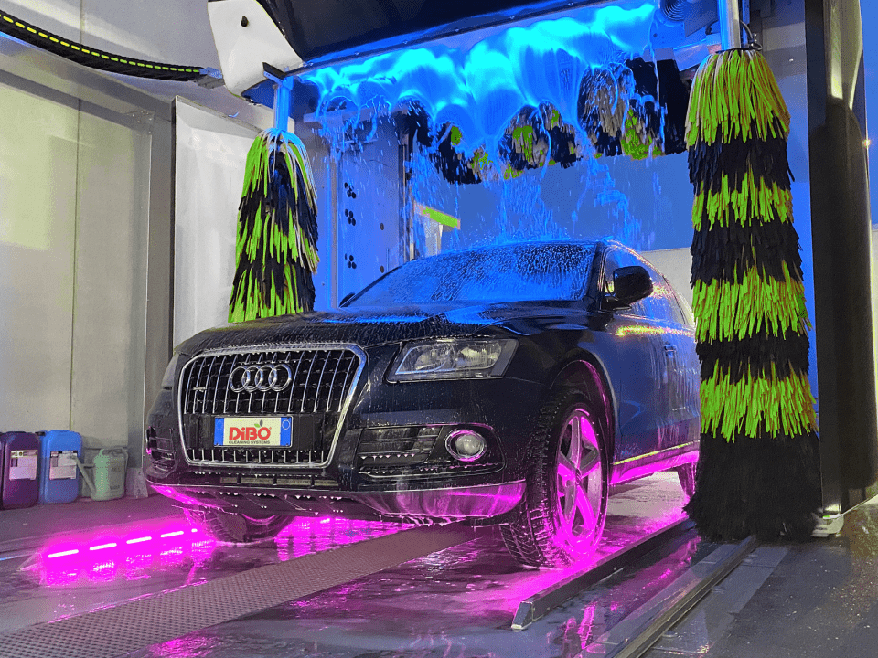 Met blauw LED verlicht water valt vertraagd neer op de auto, dit samen met fel roze verlichting van de wielen en onderkant-sfeervol autowassen. 